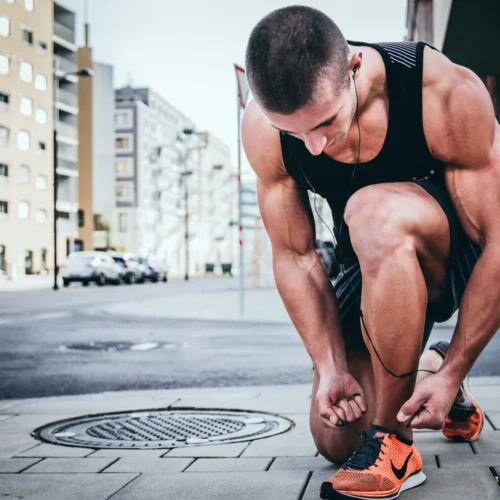 Photo by Alexander Red man tying his shoes