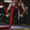 Photo by mob alizadeh a man doing a push up on a red rope