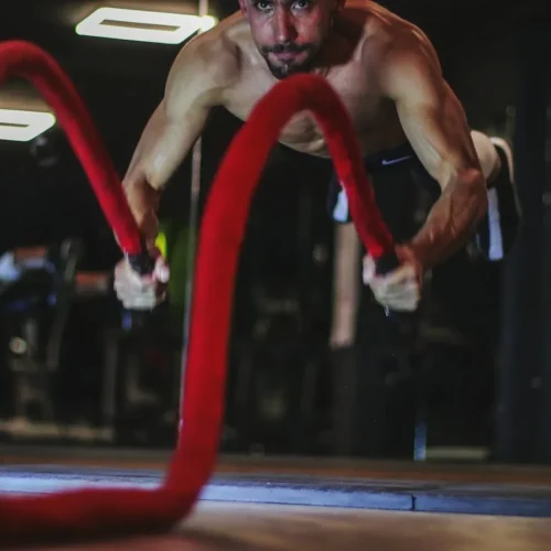 Photo by mob alizadeh a man doing a push up on a red rope