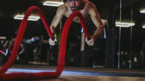 Photo by mob alizadeh a man doing a push up on a red rope
