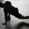 Photo by Pixabay Silhouette of a man executing a stretching routine in a dim gym environment.