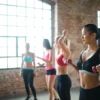 Photo by Andrea Piacquadio Determined pensive Asian female in black activewear holding dumbbells while training in group of other female athletes in in loft spacious gym