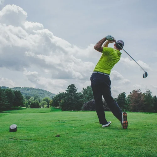 Photo by Courtney Cook photo of man swinging golf driver